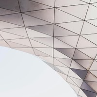Abstract architectural detail showcasing a geometric pattern with triangles under natural light.